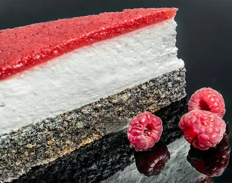 Himbeermohntorte steht auf einem Teller am Tisch