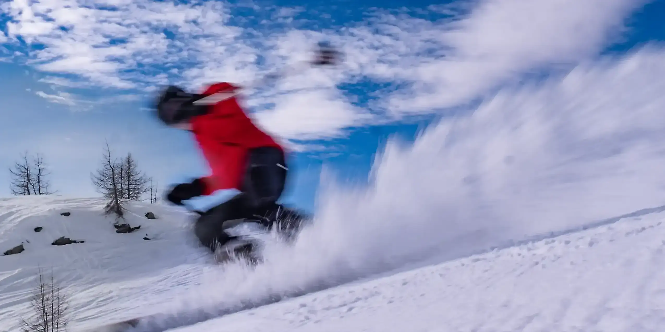 Schifahrer fährt sportlichen Schwung und staubt mit Schnee