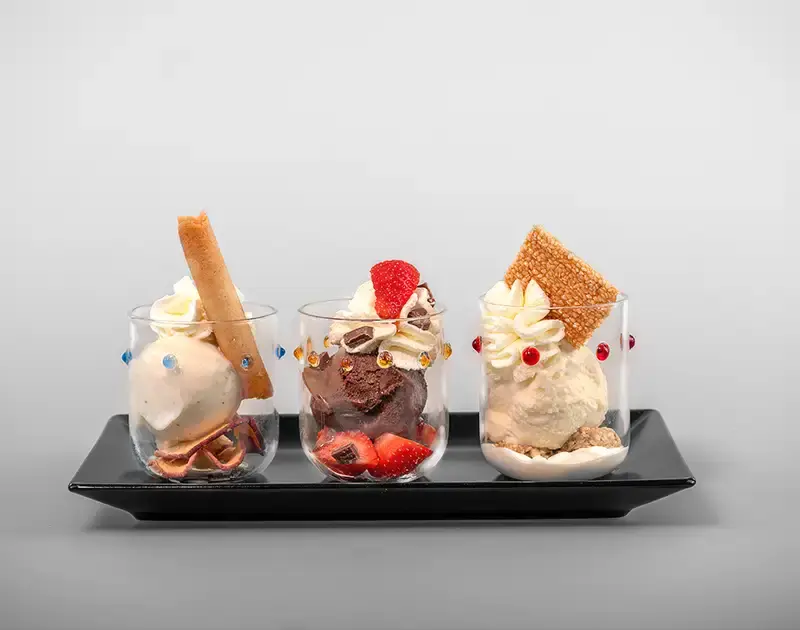 3 Glasses with ice cream on a black plate 