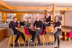 Team Cafe Brückenwirt sitzt vor der Bar des Cafe Brückenwirt