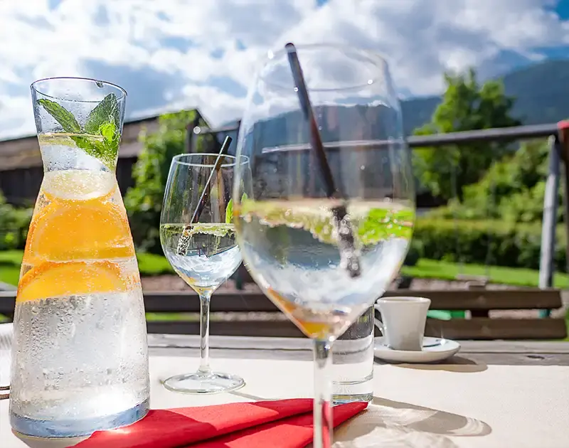 Tisch mit 2 Gläsern mit Wasser und Zitrone im Sonnenlicht